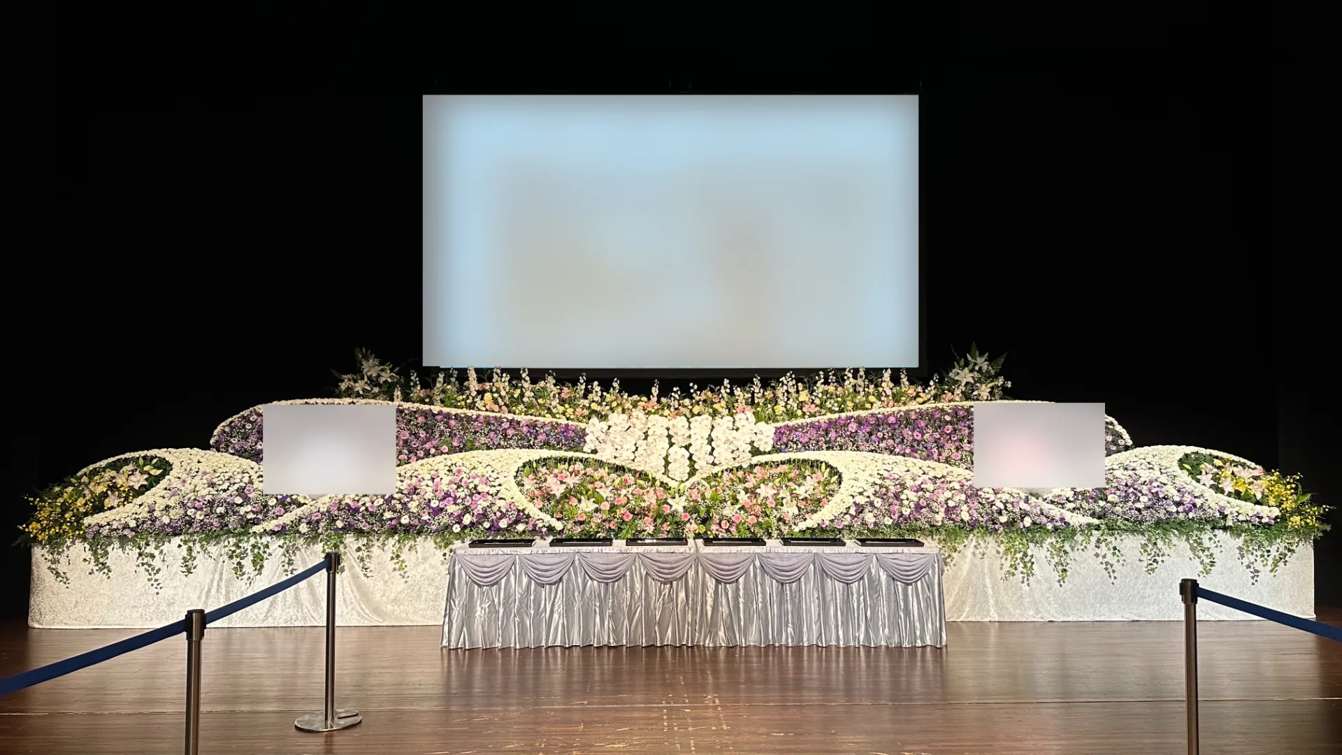 芸術文化ホールくららの大ホールに設えた一面の生花祭壇