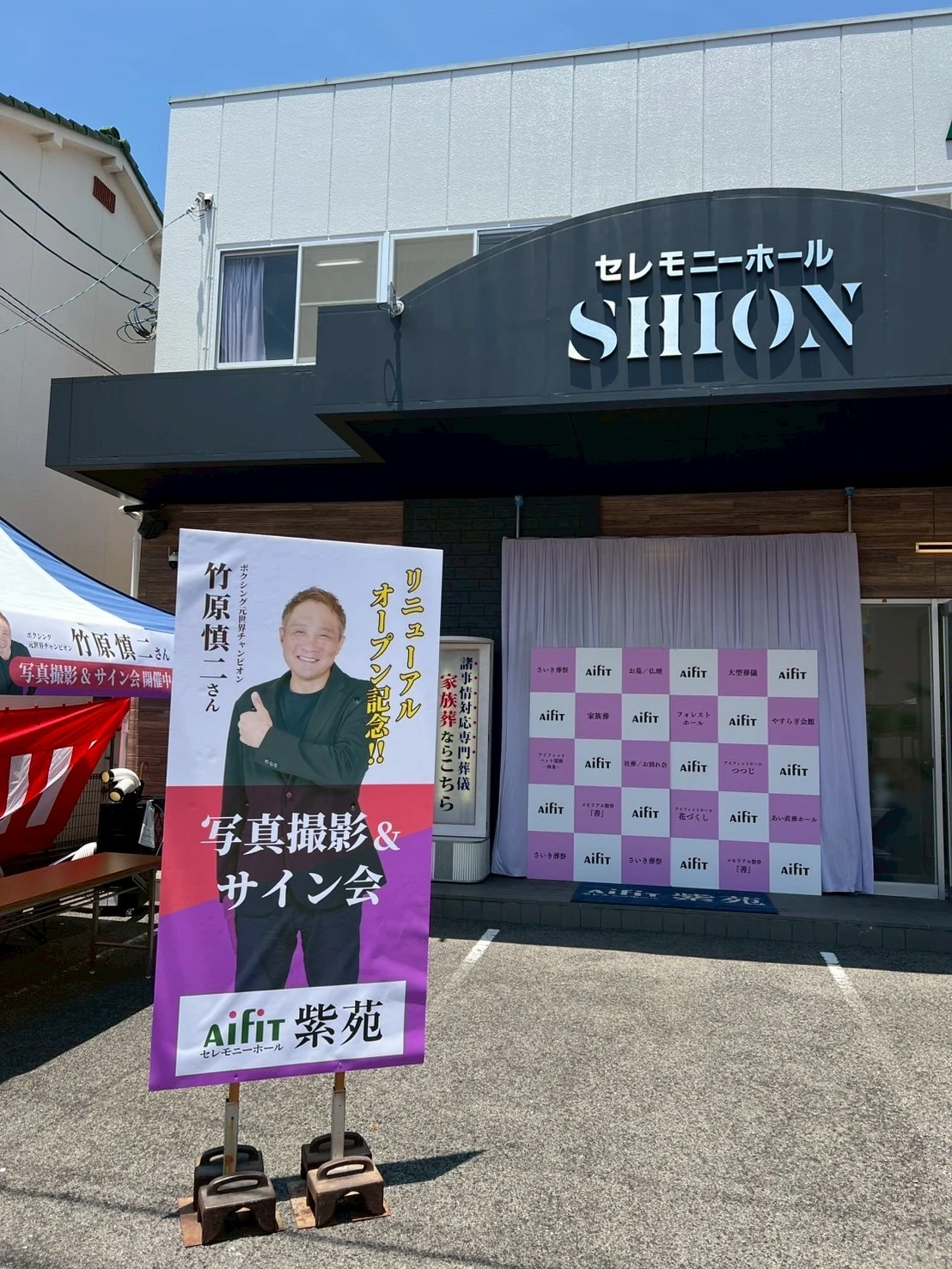 セレモニーホール紫苑の外観と、竹原慎二さん リニューアルオープン記念 写真撮影&サイン会の案内バナー